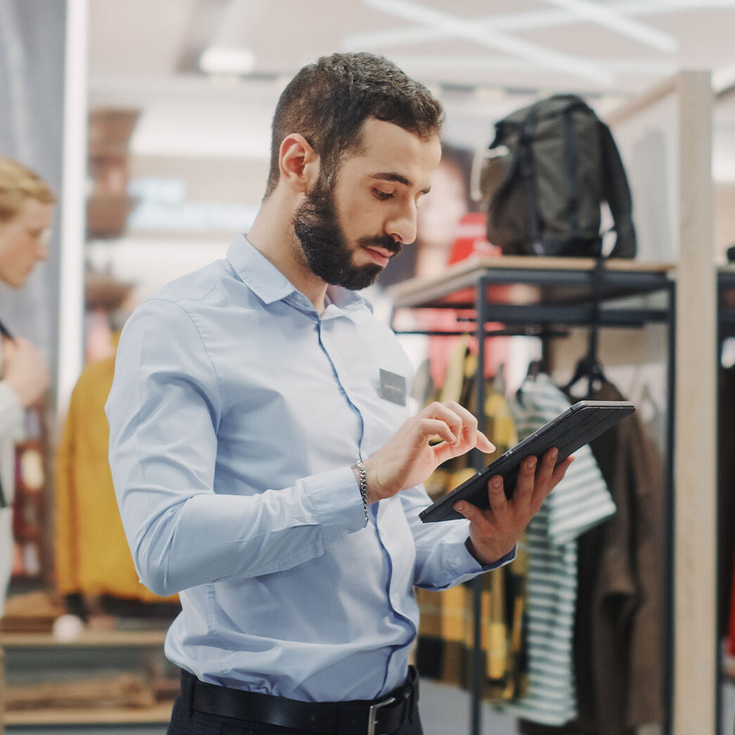 Inventory specialist using a tablet in a retail store for stock management and inventory control.