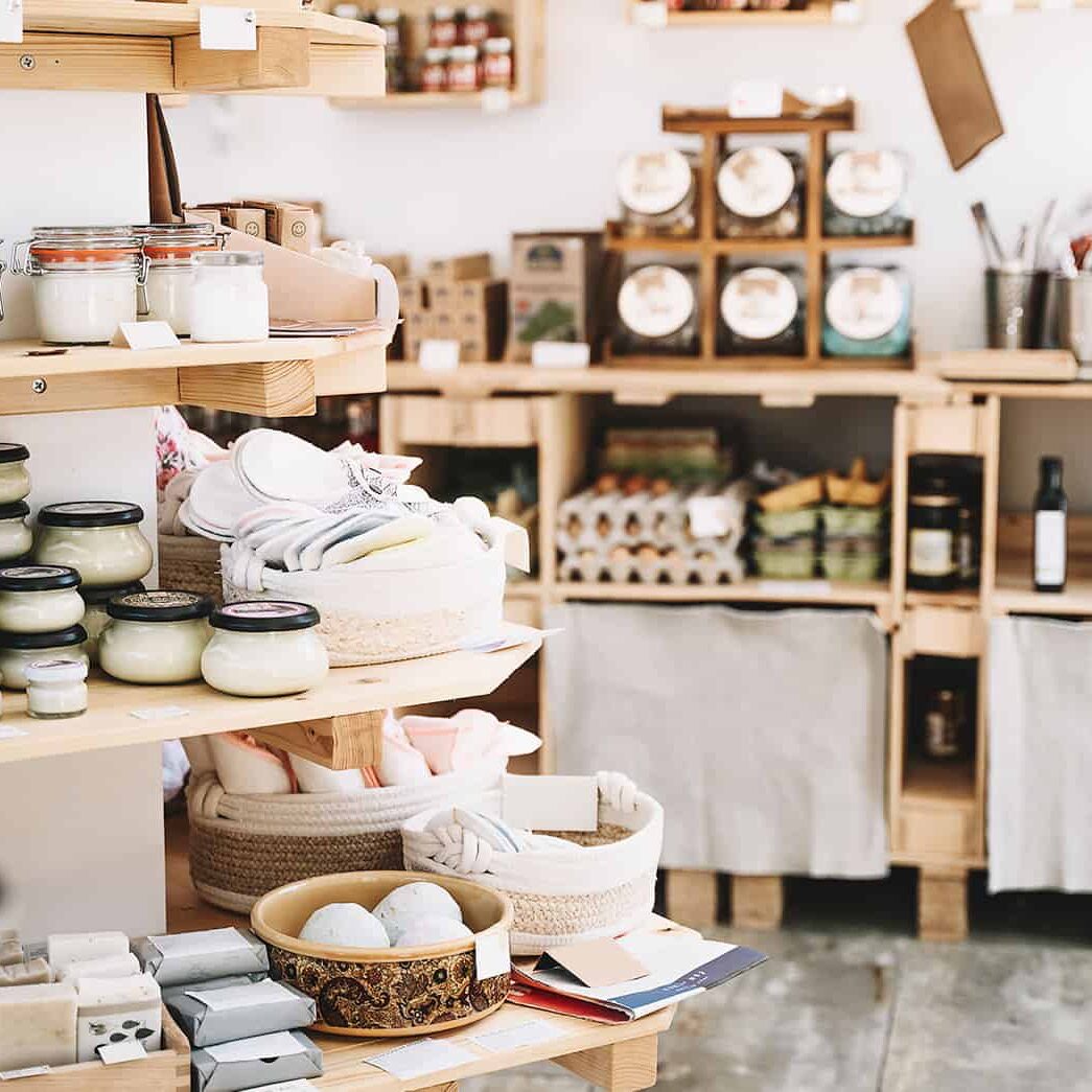 Vast display of branded candles, skincare products, and home decor items on wooden shelves at PICS Inventory Specialists store, emphasizing inventory management and retail organization for home goods.